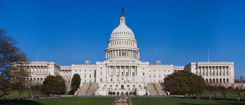 Fachada del Capitolio de Estados Unidos en Washington, con la bandera estadounidense ondeando.