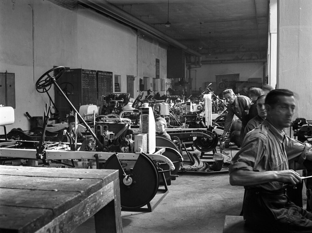 Un mecánico revisa el motor de un carro en un taller, en una imagen que ilustra el aumento del costo del mantenimiento vehicular en Colombia