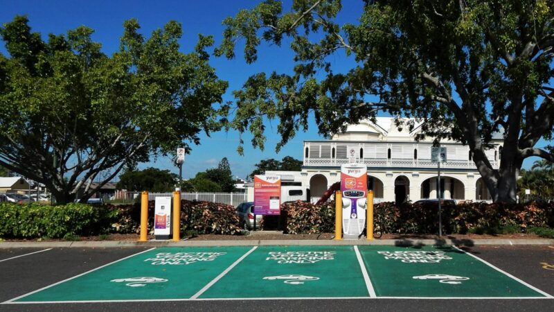 Un vehículo eléctrico conectado a una estación de carga en una ciudad colombiana