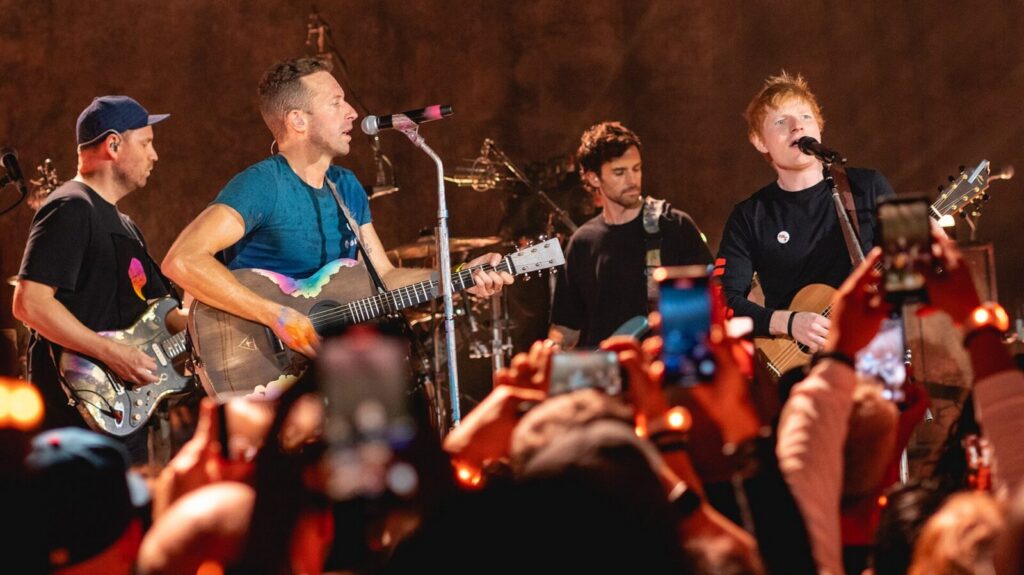 Ed Sheeran cantando en el escenario durante un concierto de su gira Loop Tour