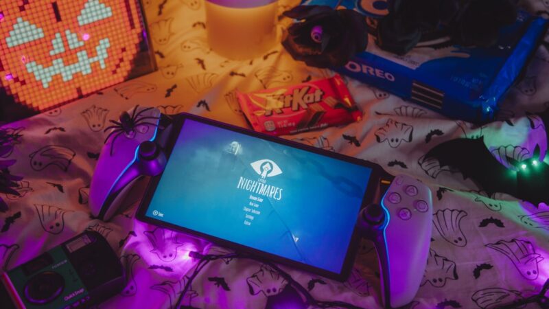 Control de videojuegos en primer plano con luces de neón de fondo, evocando la industria del entretenimiento digital.