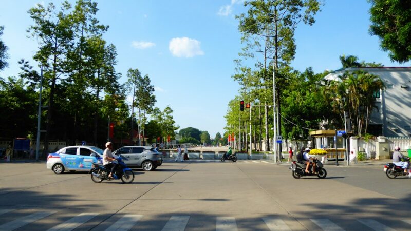 Calle de una ciudad con tráfico de vehículos y motocicletas