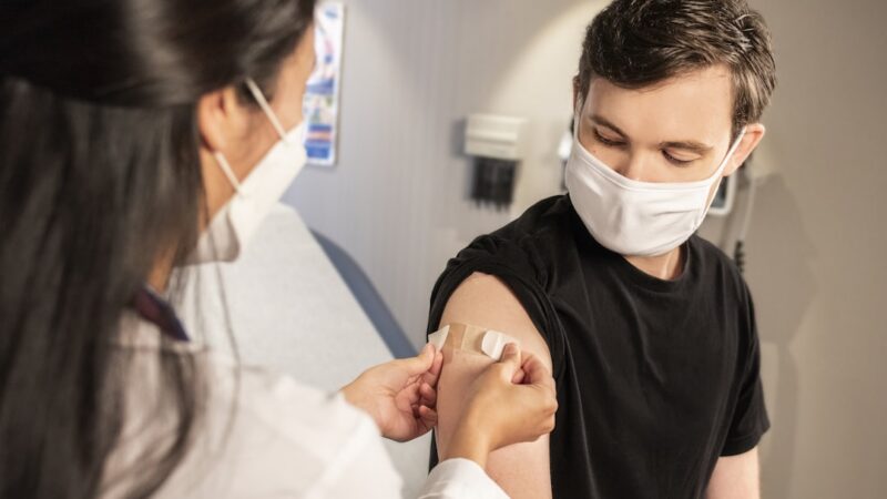 Profesional de la salud aplicando una vacuna en un punto de vacunación