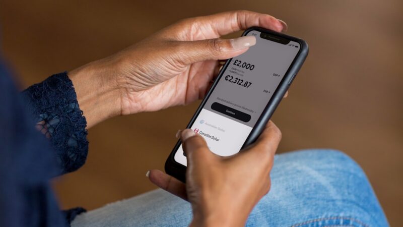 Persona sosteniendo un teléfono móvil con una aplicación de banca digital abierta