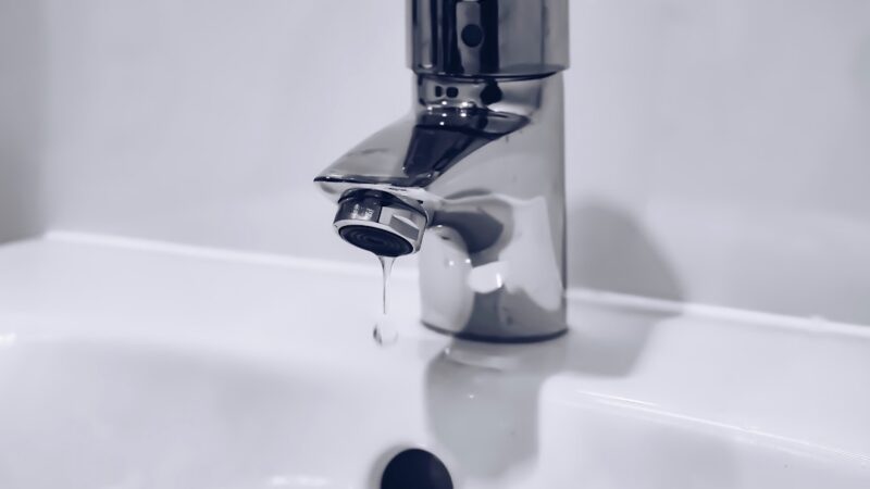 Grifo de agua abierto con chorro de agua potable