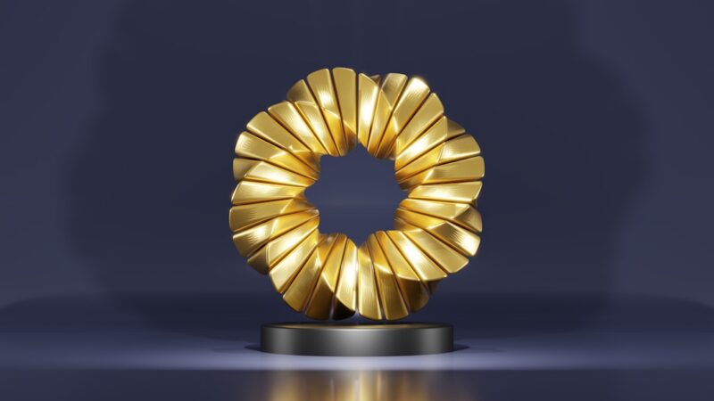 Figura dorada de la estatuilla de los premios Emmy iluminada en un escenario de premiación