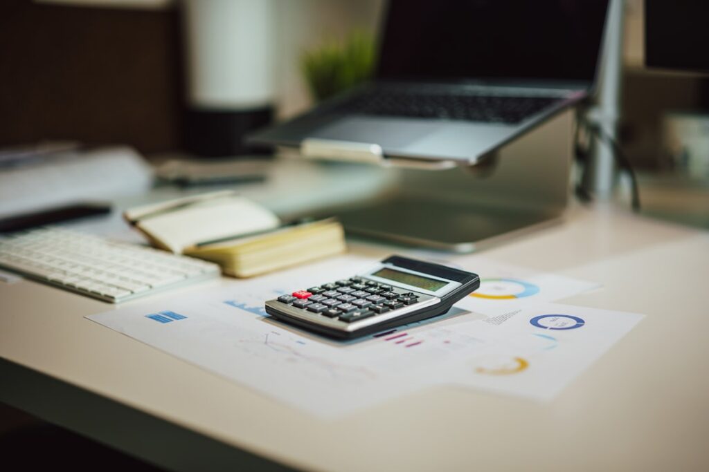Papeles con formularios tributarios y una calculadora sobre un escritorio