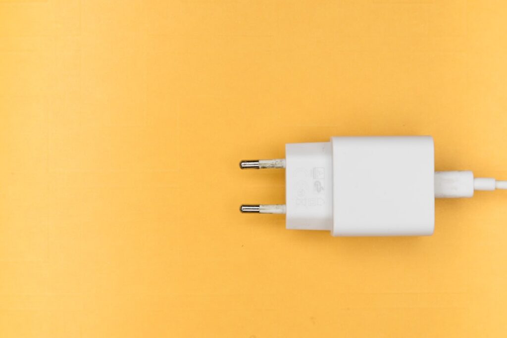 Teléfono inteligente con cable de carga conectado y pantalla encendida durante la noche