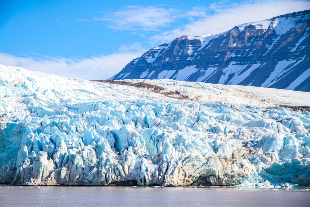 Vista de un glaciar derritiéndose junto al mar, representando la pérdida de hielo de las capas de Groenlandia y la Antártida