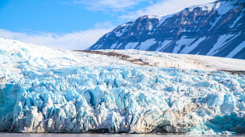 Vista de un glaciar derritiéndose junto al mar, representando la pérdida de hielo de las capas de Groenlandia y la Antártida