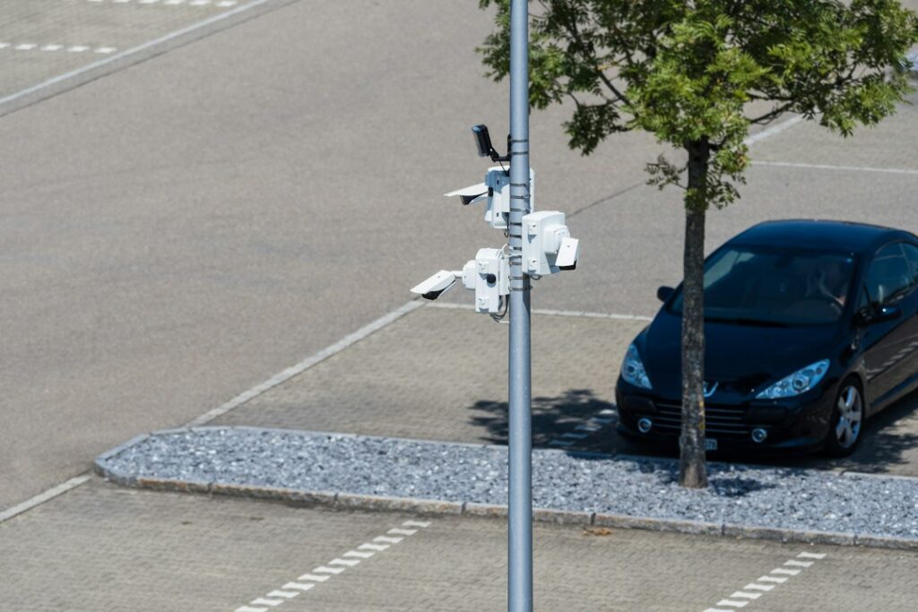 Vehículo particular estacionado junto al andén en un sector urbano, con cámaras de seguridad en el entorno