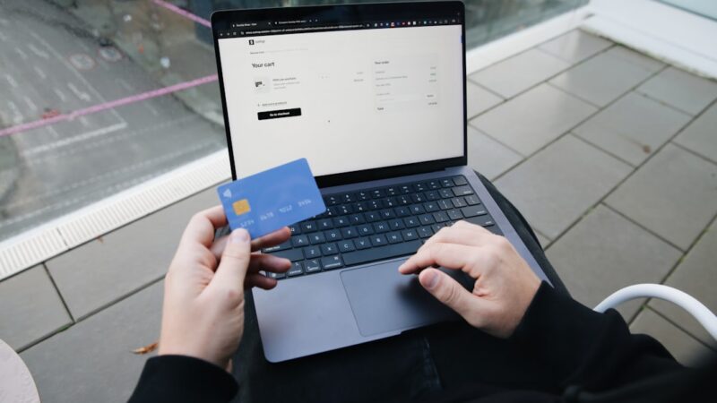 Persona realizando una compra por internet con tarjeta desde un dispositivo móvil