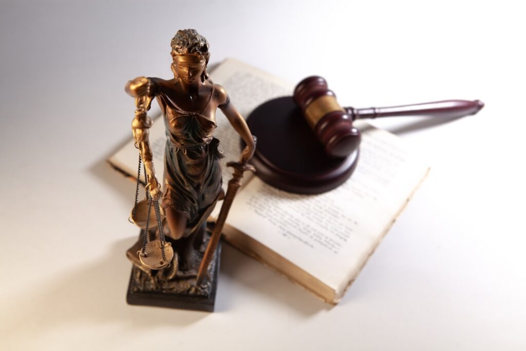 Balanzas de la justicia y un mazo de juez, símbolos del derecho que ilustran la ley de sometimiento
