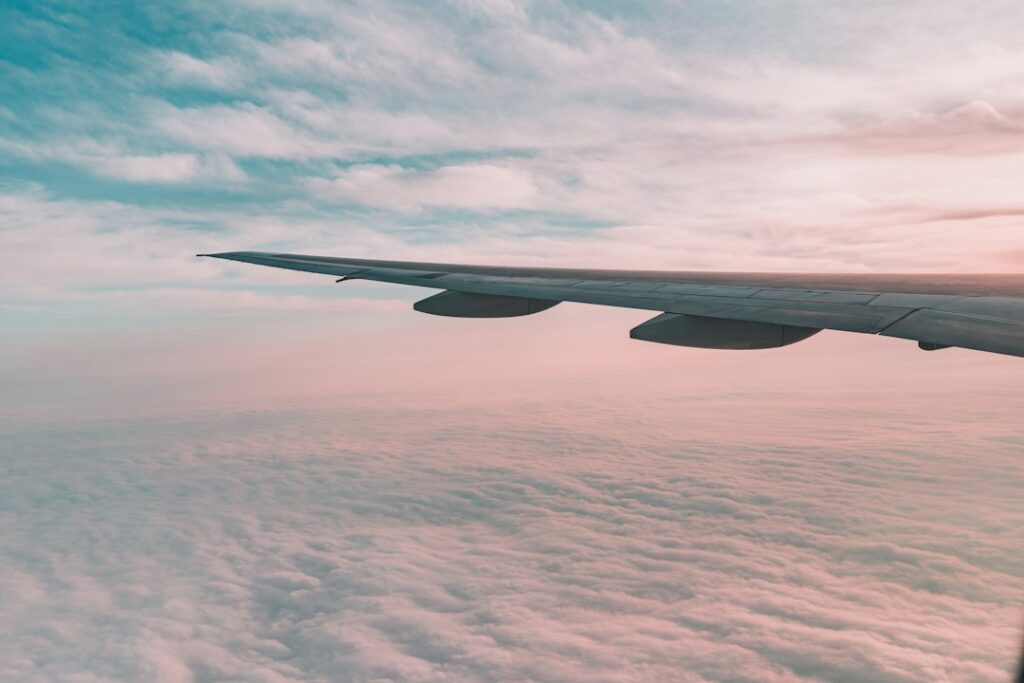 Avión comercial en vuelo con el ala y el cielo de fondo, en alusión al aumento de las búsquedas de vuelos hacia Colombia.