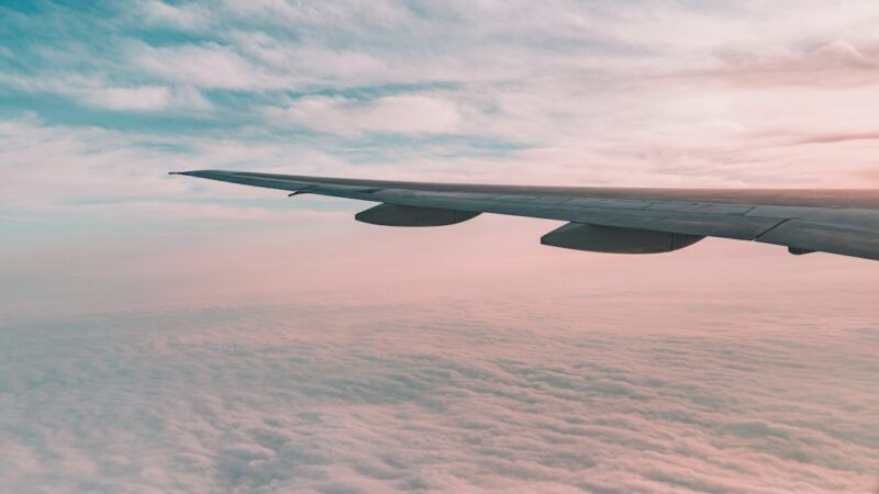 Avión comercial en vuelo con el ala y el cielo de fondo, en alusión al aumento de las búsquedas de vuelos hacia Colombia.