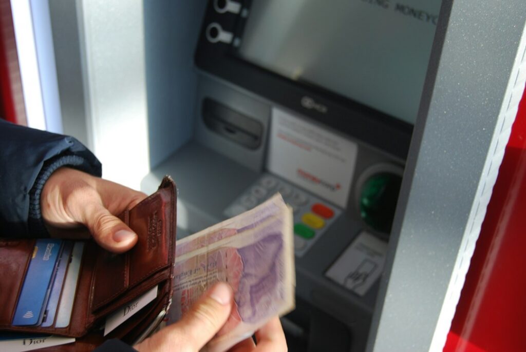 Persona recibiendo billetes en el mostrador de una tienda