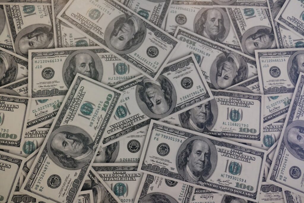 Billetes de dólar sobre una superficie, representando la cotización de la divisa en el mercado colombiano