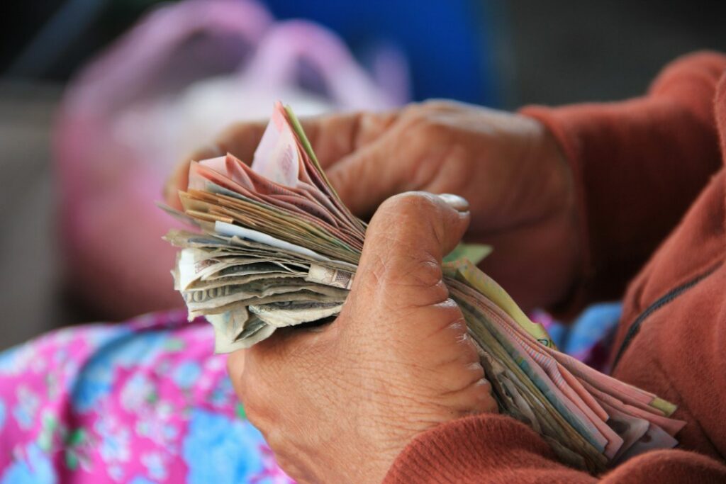 Persona mayor sosteniendo dinero en efectivo, en referencia al subsidio Colombia Mayor