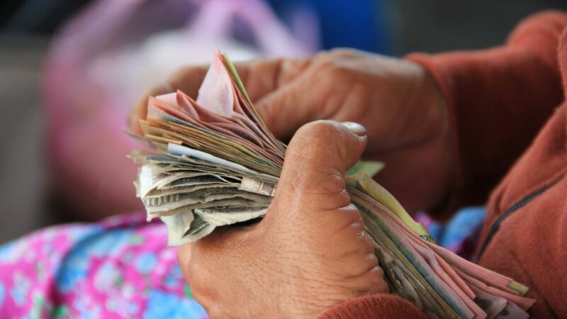 Persona mayor sosteniendo dinero en efectivo, en referencia al subsidio Colombia Mayor