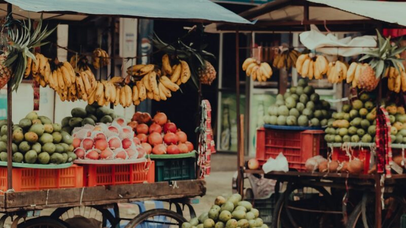 Peatones recorriendo un sector comercial de calle con tiendas y restaurantes en una ciudad colombiana