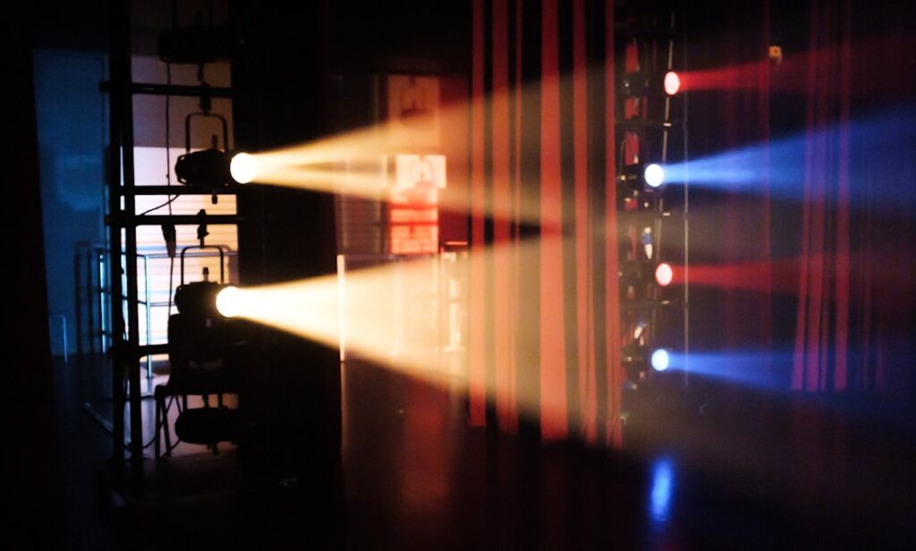 Equipo de producción trabajando en la organización de un concierto con luces y estructura de escenario