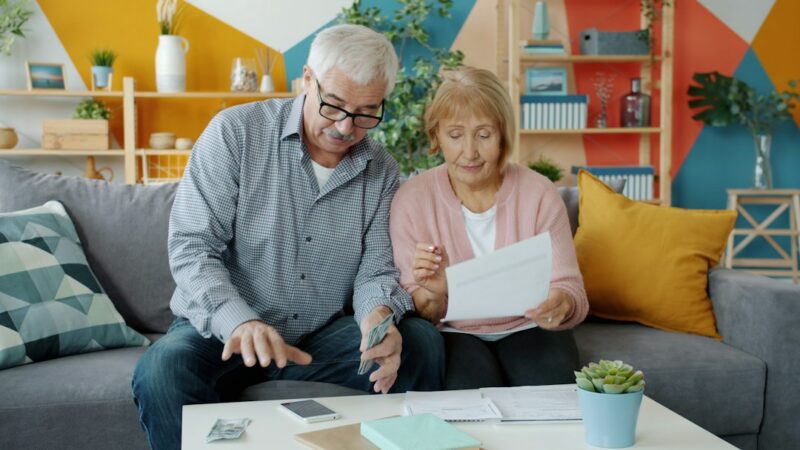 Persona mayor revisando documentos y calculadora relacionados con su pensión