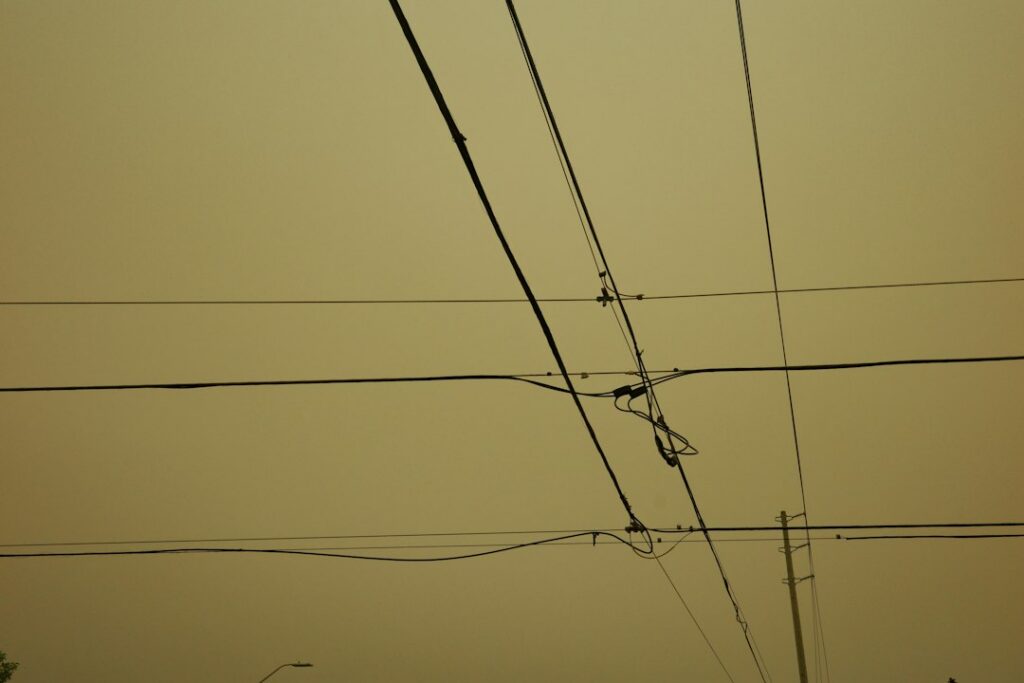 Poste con múltiples cables eléctricos y de telecomunicaciones sobre una calle urbana, el problema que busca atender el soterramiento de redes en Bogotá