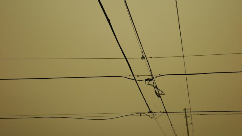 Poste con múltiples cables eléctricos y de telecomunicaciones sobre una calle urbana, el problema que busca atender el soterramiento de redes en Bogotá