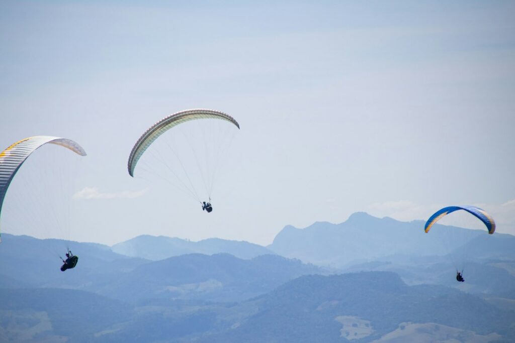 Un parapente vuela sobre una zona montañosa, actividad similar a la que se realizaba cuando ocurrió el accidente en Bello