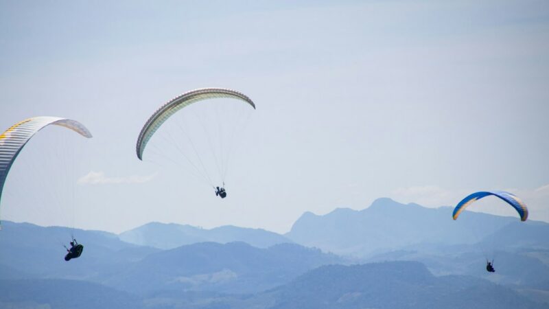 Un parapente vuela sobre una zona montañosa, actividad similar a la que se realizaba cuando ocurrió el accidente en Bello