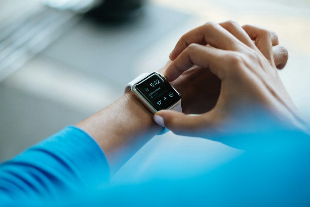 Una persona con una pulsera inteligente en la muñeca, uno de los dos formatos de wearables que se comparan en esta guía.