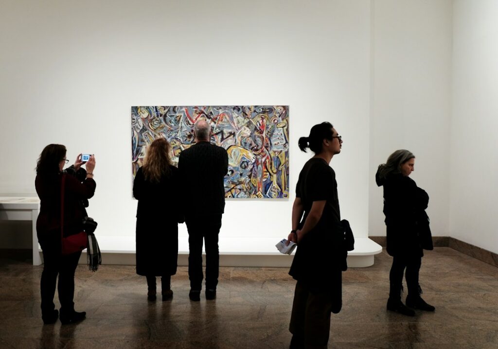 Visitantes recorren una galería de arte con obras expuestas durante una feria internacional