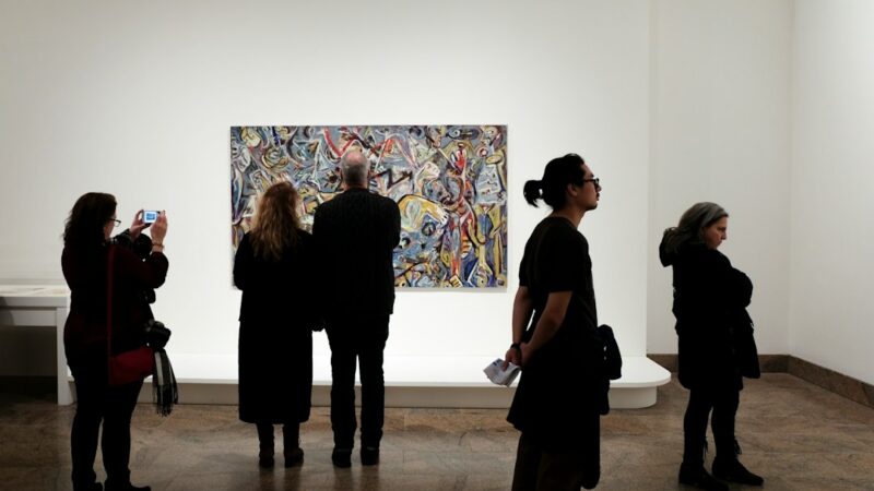 Visitantes recorren una galería de arte con obras expuestas durante una feria internacional