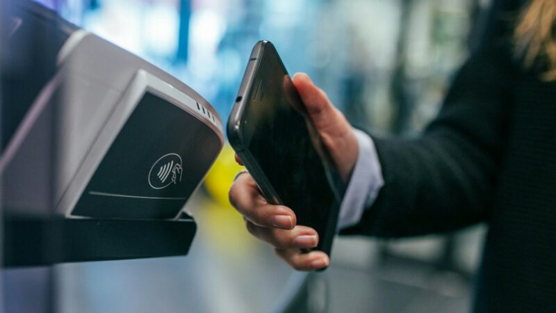 Persona realizando un pago digital con su celular en una aplicación bancaria