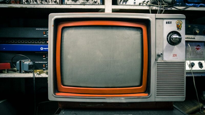 Televisión antigua encendida en una sala, símbolo de la nostalgia que explota la industria del entretenimiento con reboots y revivals