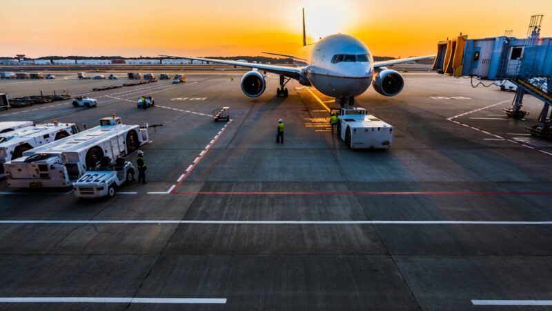 Un avión comercial despegan pasajeros en la terminal de un aeropuerto antes de un vuelo.