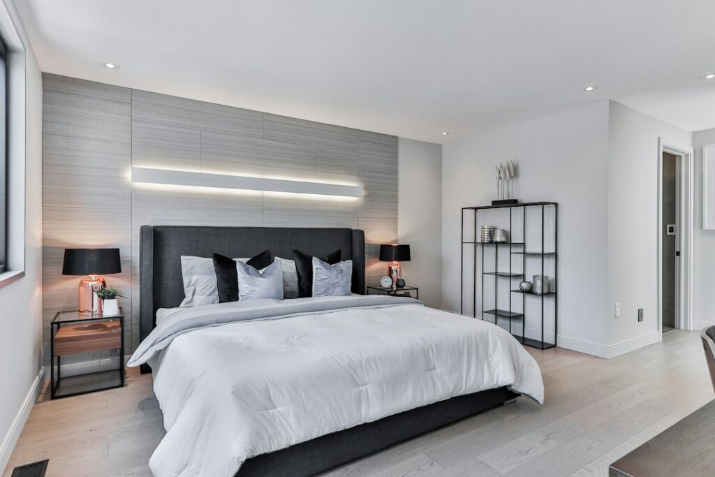 Dormitorio con la pared detrás de la cama intervenida con revestimiento decorativo, sin respaldo independiente