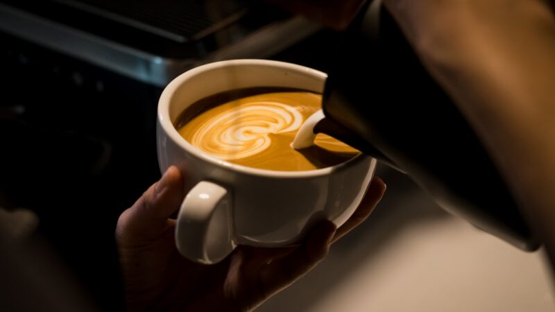 Barista preparando una taza de café filtrado en un escenario de feria