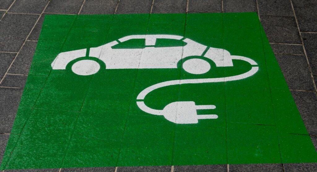 Carro híbrido conectado a una estación de carga, imagen relacionada con los beneficios tributarios para vehículos eléctricos e híbridos en Colombia