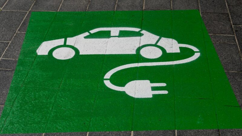 Carro híbrido conectado a una estación de carga, imagen relacionada con los beneficios tributarios para vehículos eléctricos e híbridos en Colombia