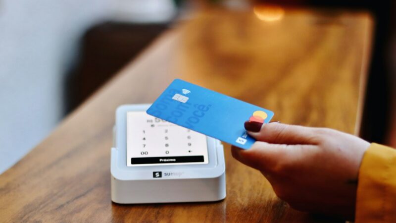 Una persona acerca su tarjeta a un datáfono para pagar sin contacto, modalidad que en Colombia ya supera el 90 % de las transacciones.
