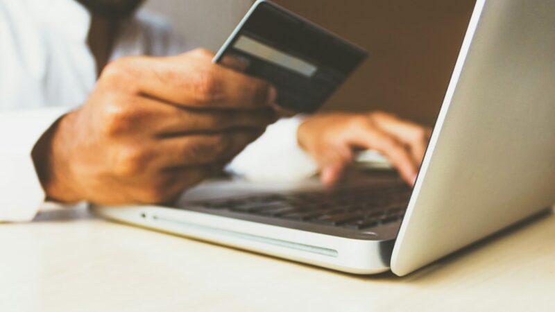 Paquetes de compras en línea junto a un computador portátil, escena alusiva al comercio electrónico transfronterizo y al flujo de envíos internacionales
