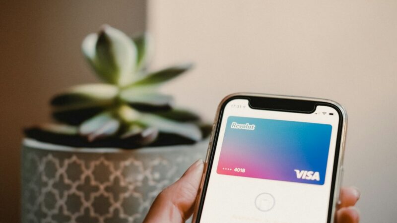 Persona realiza un pago sin contacto acercando una tarjeta a un iPhone que funciona como terminal de pago