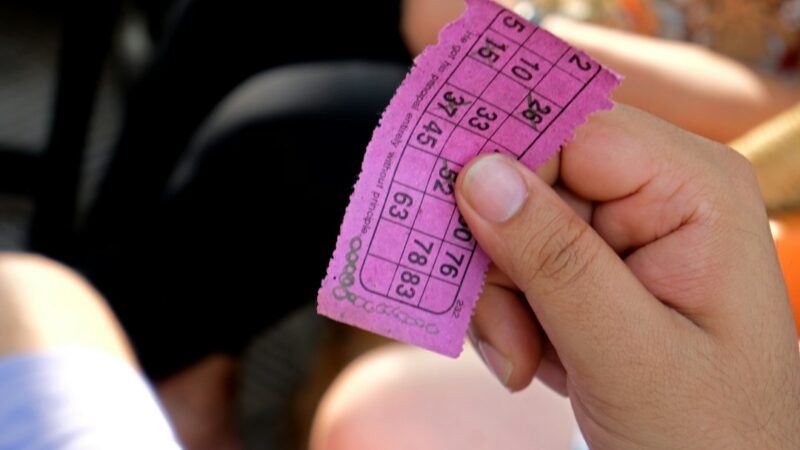 Manos sosteniendo un billete de lotería tras conocerse los resultados del sorteo