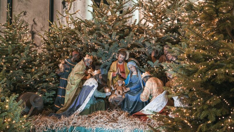 Escenografía navideña con el pesebre y luces encendidas durante la noche