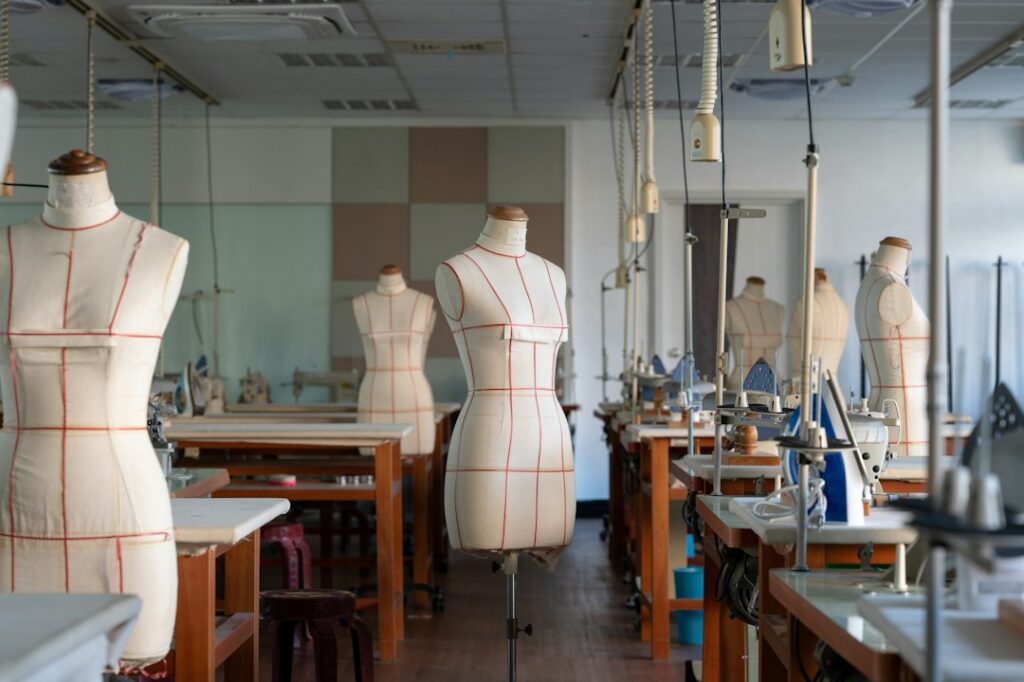 Taller de diseño de moda con prendas y materiales sobre una mesa, procesos donde la inteligencia artificial y los modelos 3D ganan terreno.