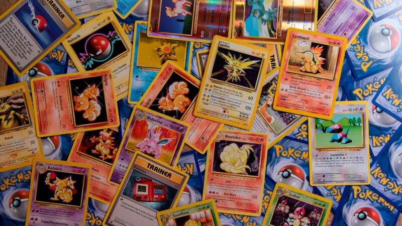 Cartas coleccionables y monedas dispuestas sobre una superficie, imagen representativa del mercado del coleccionismo