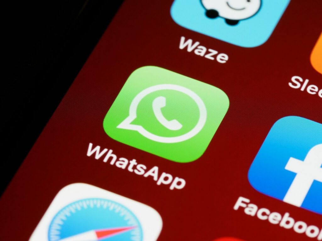Mano sosteniendo un celular con una aplicación de mensajería abierta en la pantalla