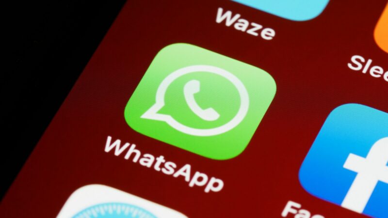 Mano sosteniendo un celular con una aplicación de mensajería abierta en la pantalla