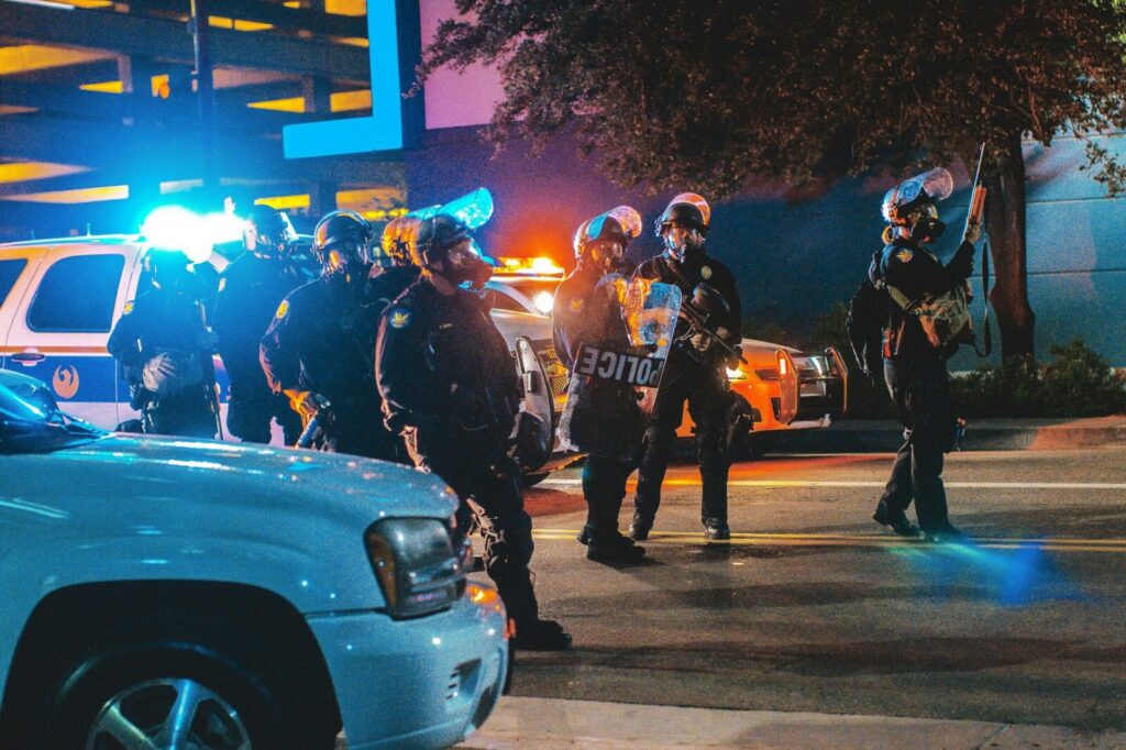 Agente de policía custodia a un detenido con esposas durante un operativo de traslado